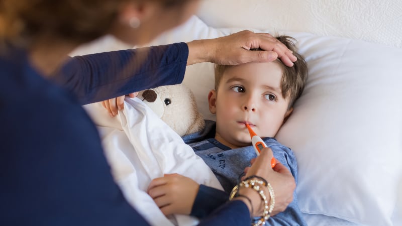 A mother checks her young son for fever