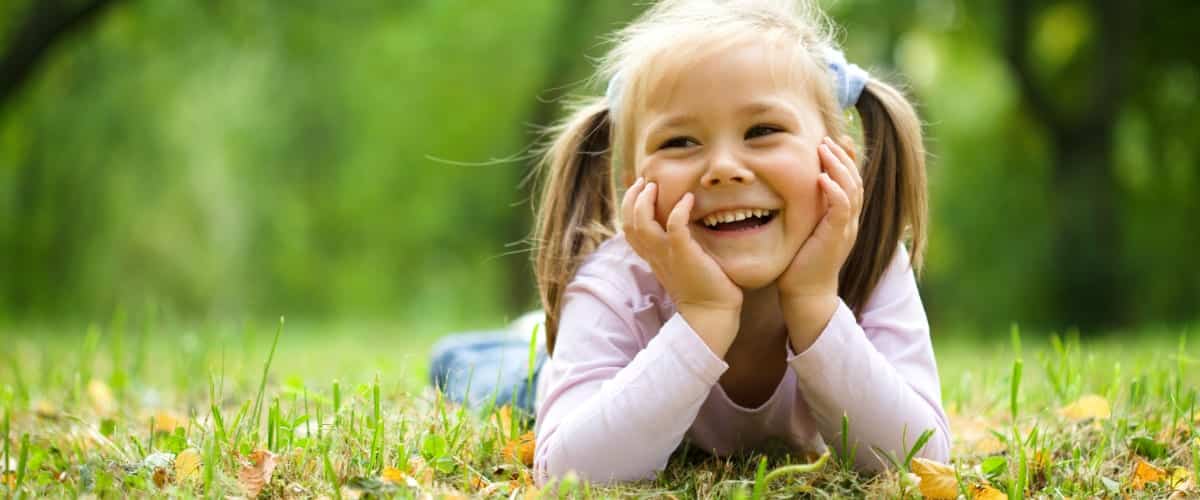 A smiling little girl laying on the grass