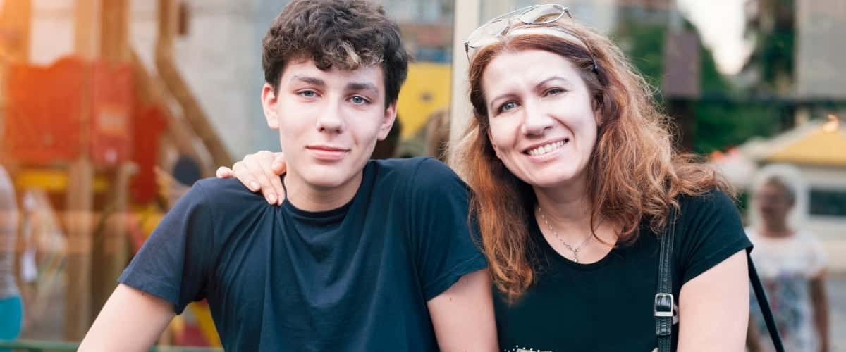 A mother sits with her teen son